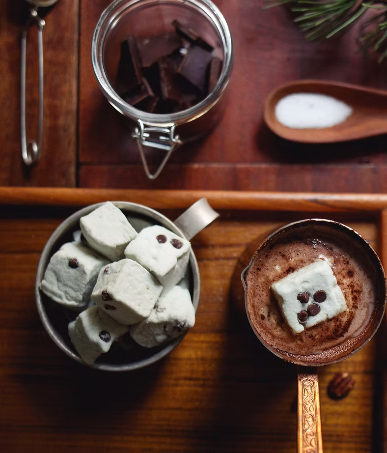 A hand pouring cocoa over a slow morning